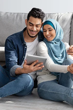 Loving Muslim Family Sitting Floor With Tablet Boxes 1